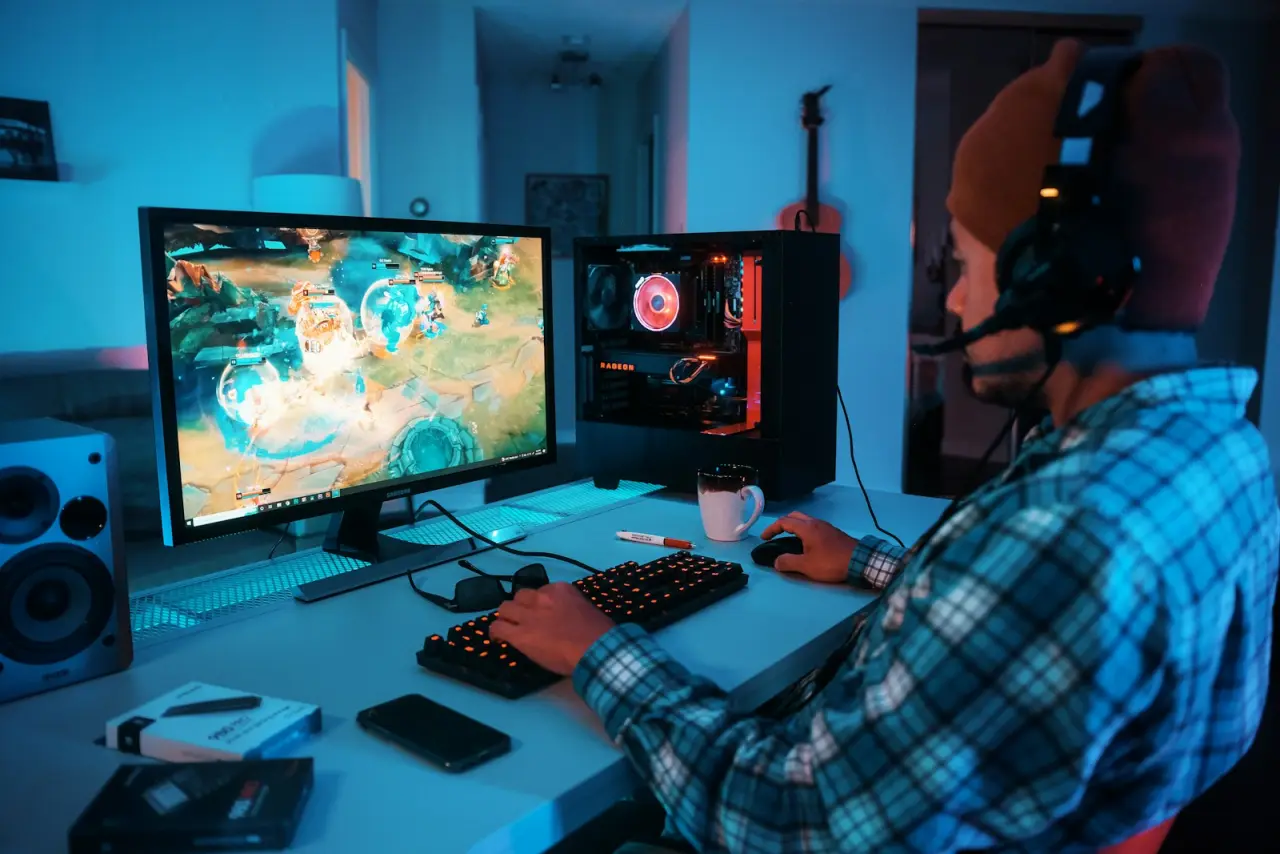 Neon ışıklandırmalı gaming istasyonunda kulaklıkla oynayan oyuncu