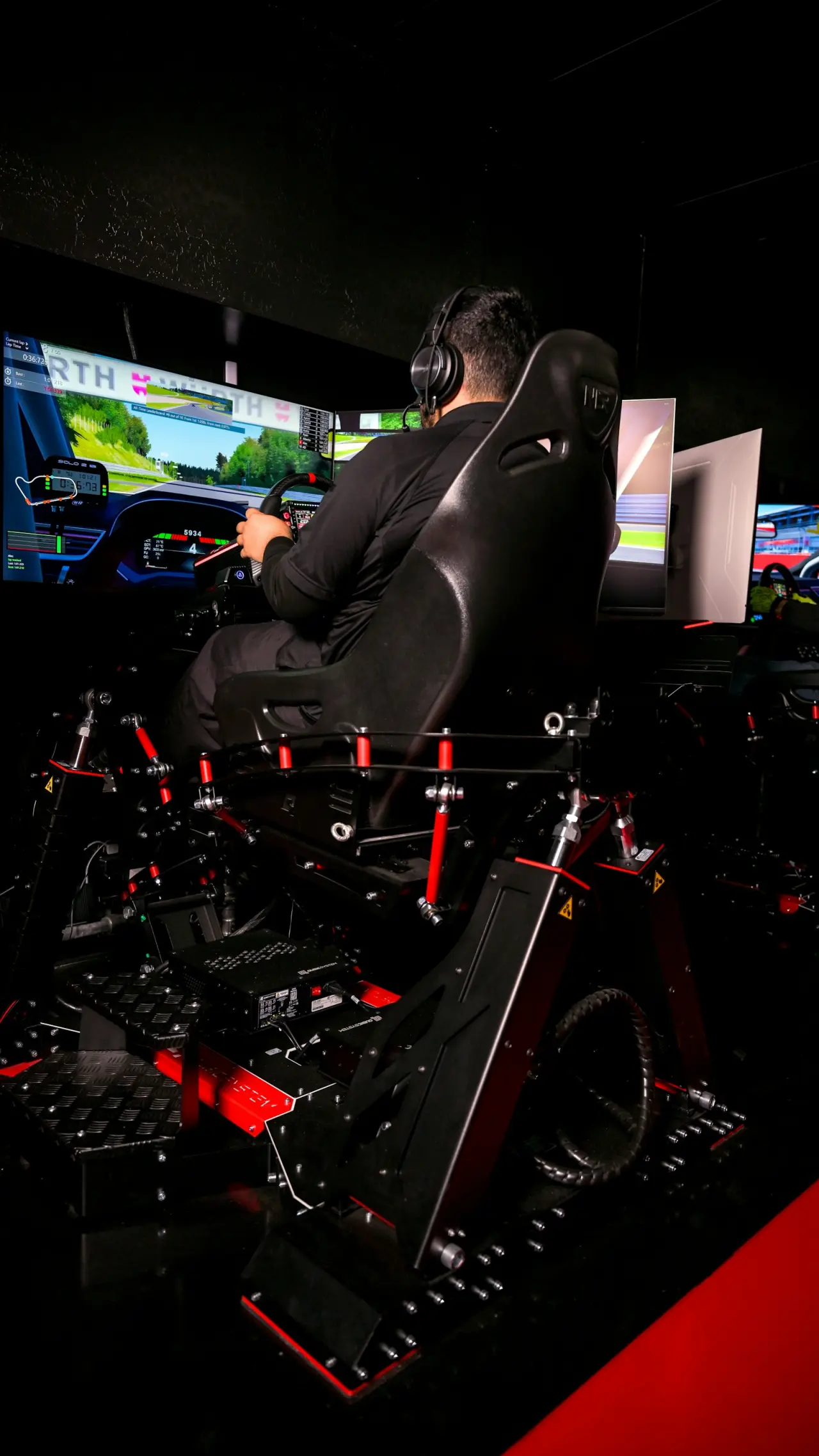 Üç ekranlı sim racing kokpitinde yarış simülasyonu